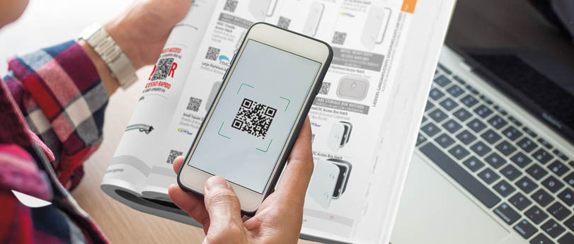 The butler is using a mobile phone to scan the QR code for the bill through the app. Convenient, fast, is an option of modern.